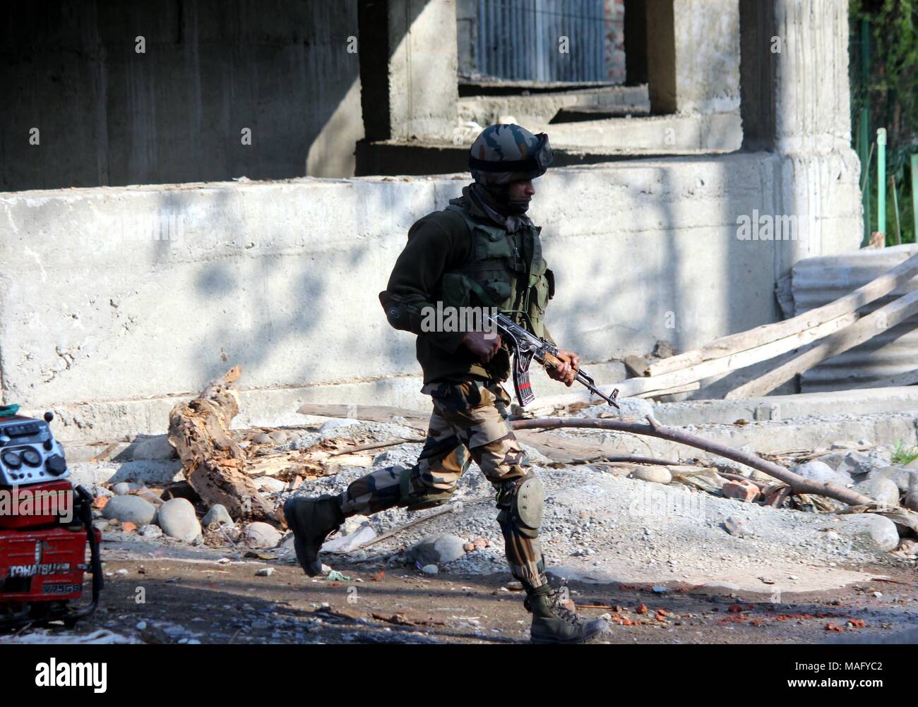 Shopin, Indien. 01 Apr, 2018. Indische Soldaten Wache bei einem Schusswechsel bei einem Schusswechsel zwischen mutmaßlichen Militanten und indische Sicherheitskräfte in Kachadora im Süden von Kaschmir Shopian Bezirk am 01, April, 2018. Im Anschluss an die Tötung von mindestens acht Rebellen im Kampf mit den Streitkräften der Regierung, sagten Beamte. Mindestens zwei Soldaten wurden auch in den Kämpfen getötet. Credit: Aasif Shafi/Pacific Press/Alamy leben Nachrichten Stockfoto