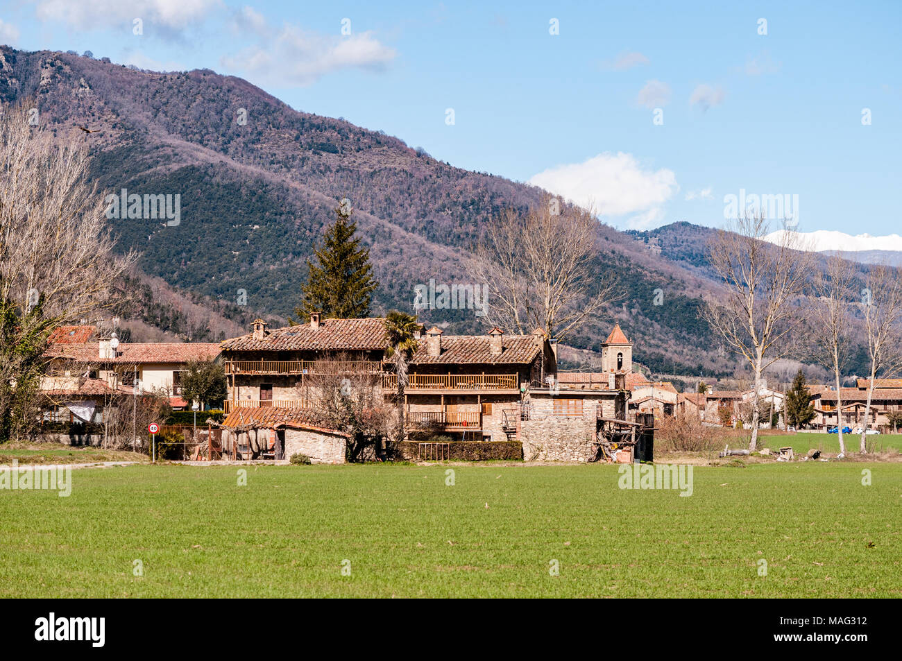 Blick auf O Barco d'en Bas-Dorf, in La Garrotxa, Katalonien, Spanien mit Bergen im Hintergrund Stockfoto