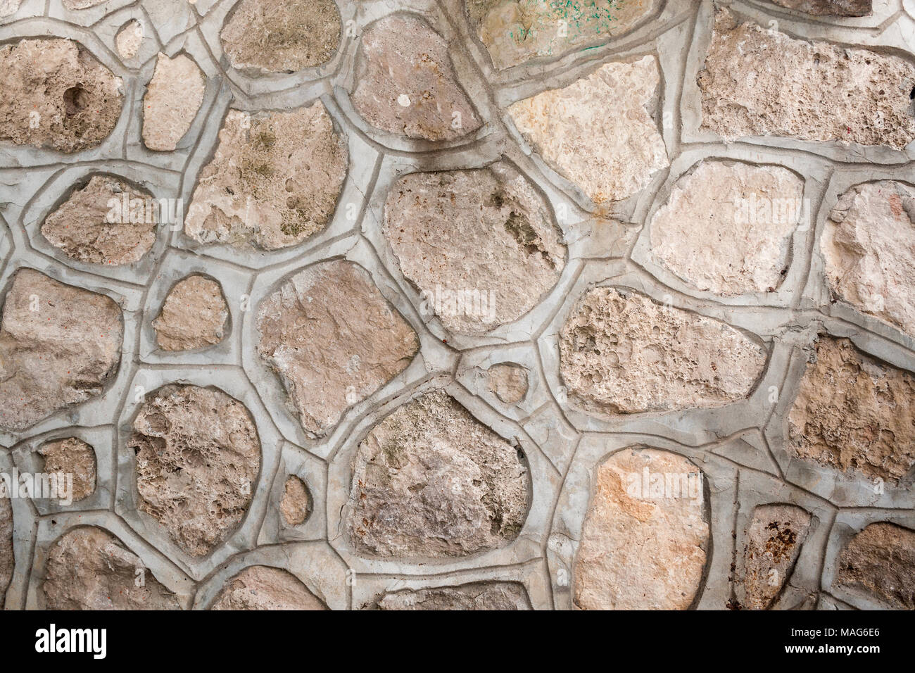 Hintergrund der natürlichen porösen Steine beliebiger Form, zusammen mit einem zementestrich. Stockfoto