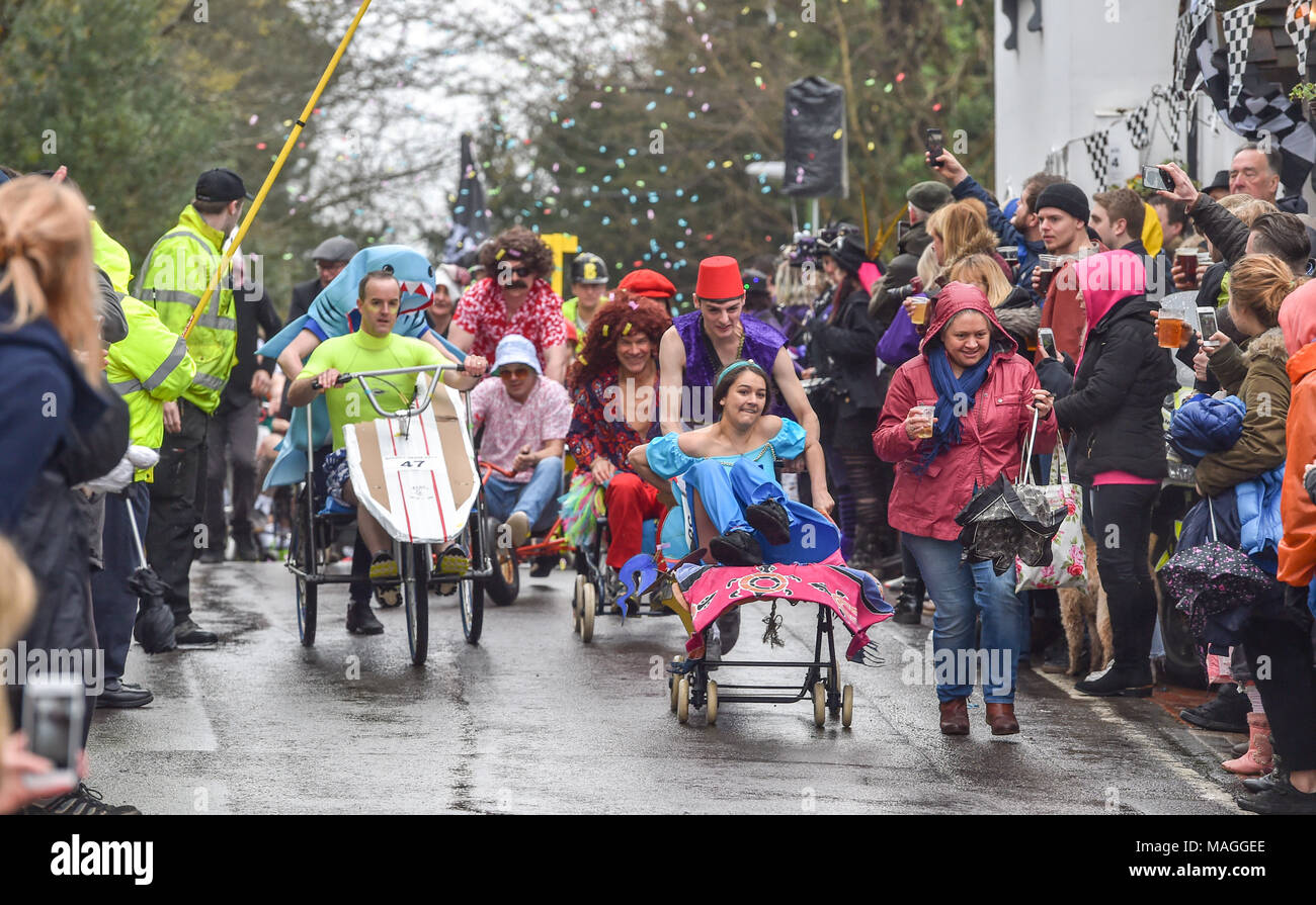 Bolney UK 2. April 2018 - Wettbewerber Rennen im strömenden Regen in der jährlichen Bolney Pram Rennen heute, die in den acht Glocken Kneipe im Dorf jeden Ostern Feiertag Montag das Geld statt für lokale Wohltätigkeitsorganisationen SERV Sussex und Alter UK Foto von Simon Dack Credit: Simon Dack/Alamy leben Nachrichten Stockfoto