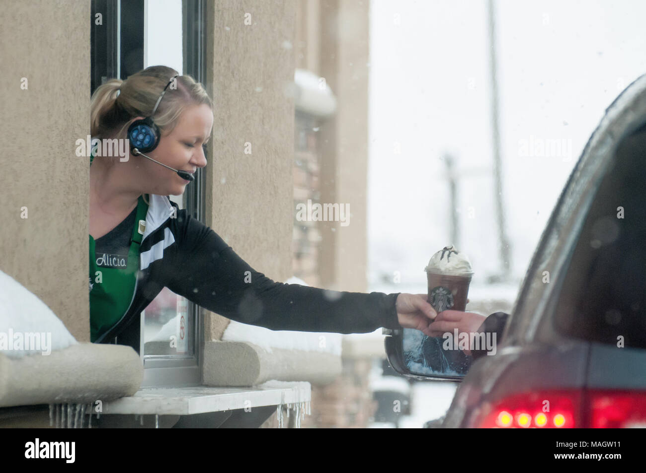 Eine Telefonzentrale austeilen einen Kaffee im Starbucks im Schnee. Stockfoto