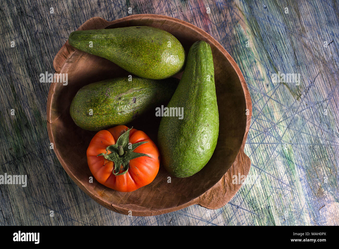 Nahaufnahme von Avocado Vielfalt und heirloom Tomaten in eine hölzerne Schüssel Stockfoto