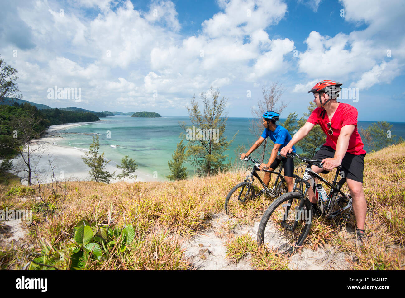 Kerle Radfahren entlang einer Landzunge, Kudat, Sabah, Malaysia, Borneo, Stockfoto