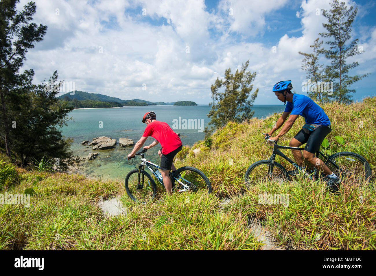 Kerle Radfahren entlang einer Landzunge, Kudat, Sabah, Malaysia, Borneo, Stockfoto