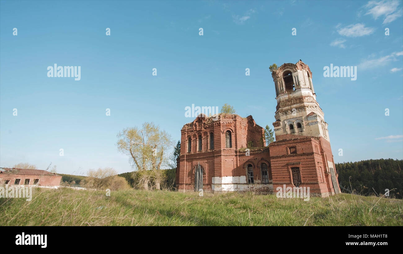 Schönen malerischen Blick auf alte buddhistische Tempel in den Hintergrund. Video. Alte russische Kirche oder Tempel mit Gras unter Feld überwachsen ruiniert Stockfoto