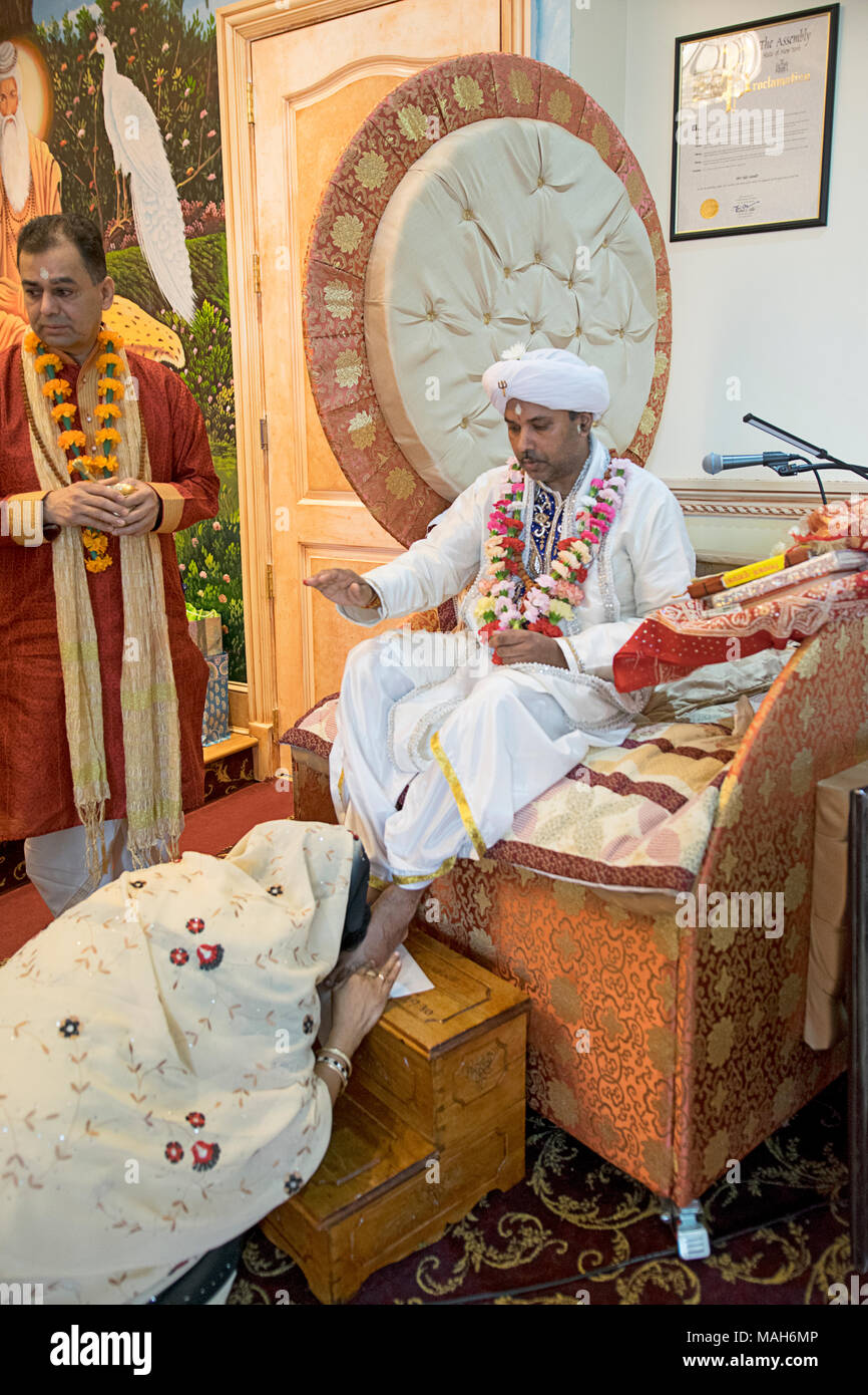 Eine weibliche Anbeter küsse die Füße der Priester an den Tulsi-Tempel in South Richmond Hill, Queens, New York. Stockfoto