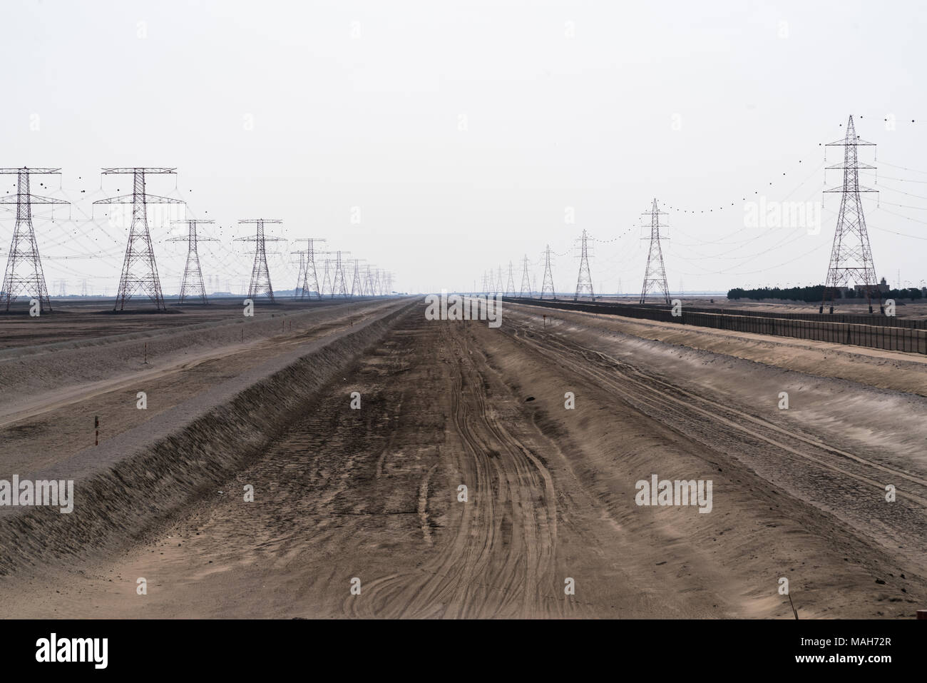 Strommasten und Hochspannungsleitungen in der Wüste der Vereinigten Arabischen Emirate Stockfoto