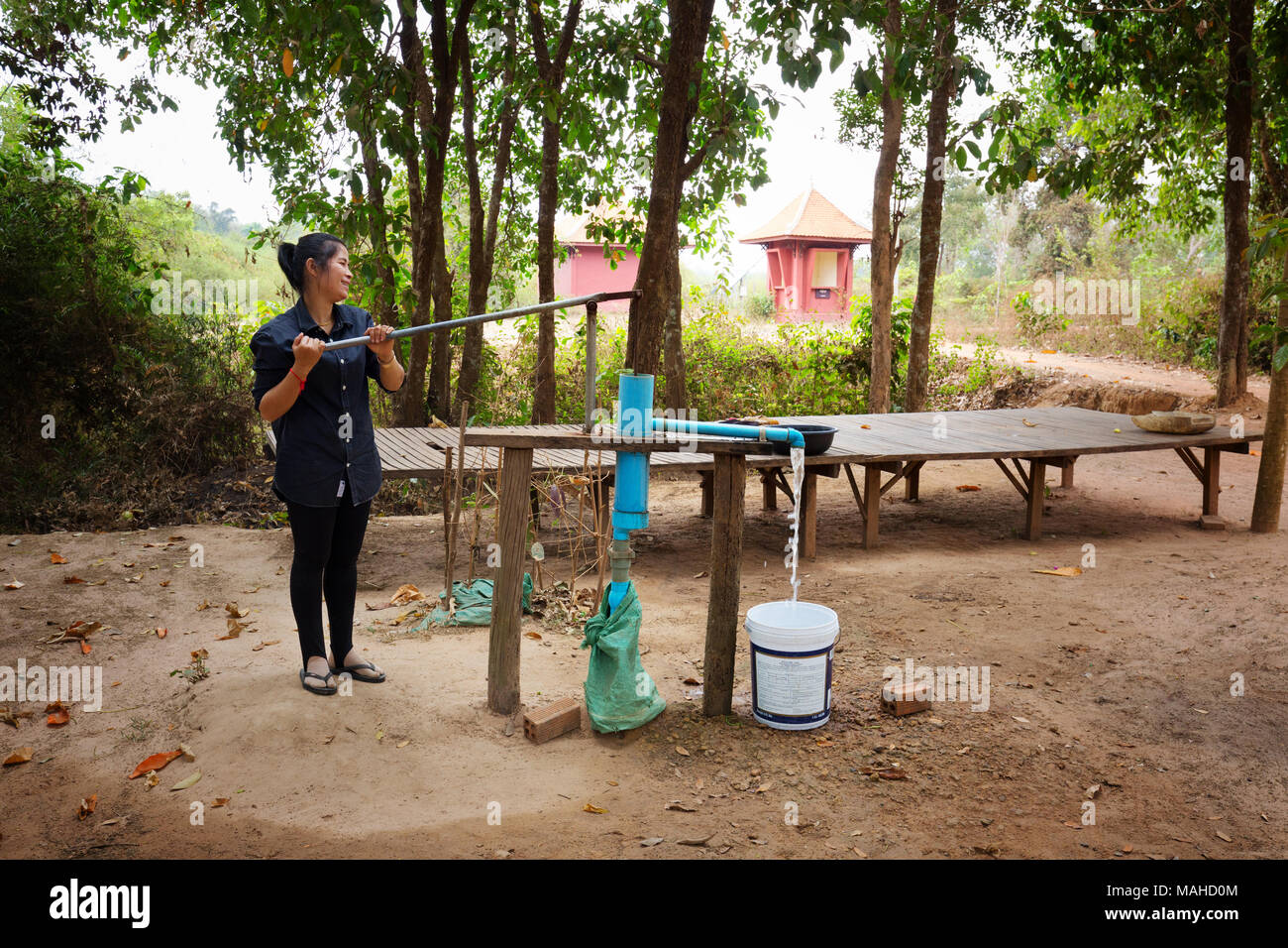 Kambodscha Lebensstil - eine Frau mit einer Handpumpe frisches Wasser zu pumpen, Kampong Thom, Kambodscha Asien Stockfoto
