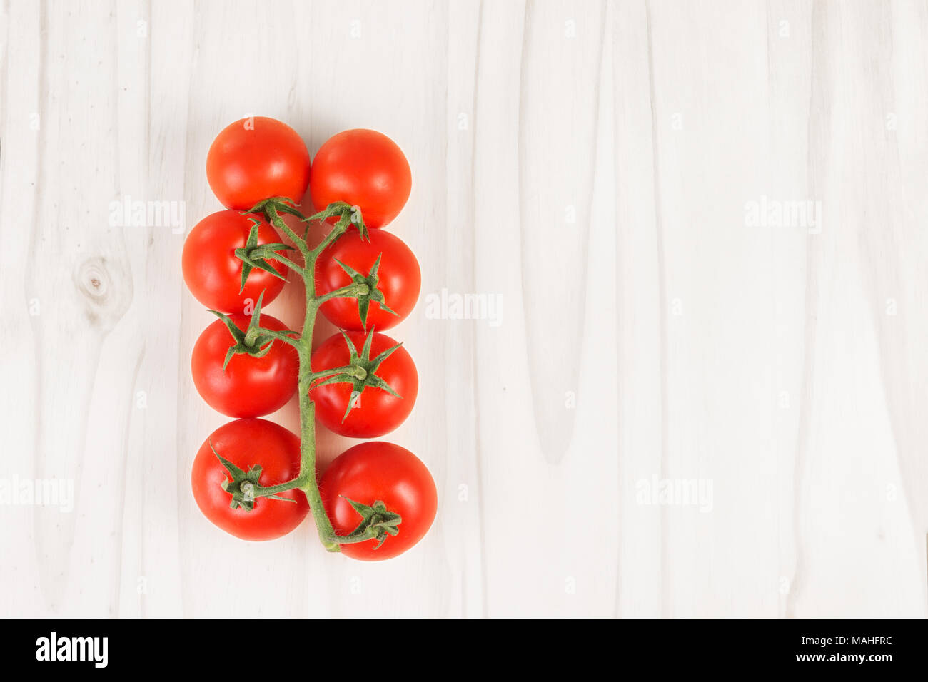 Rote Tomaten auf der Rebe auf einem weißen Holz Oberfläche Reif. Ansicht von oben. Platz kopieren Stockfoto
