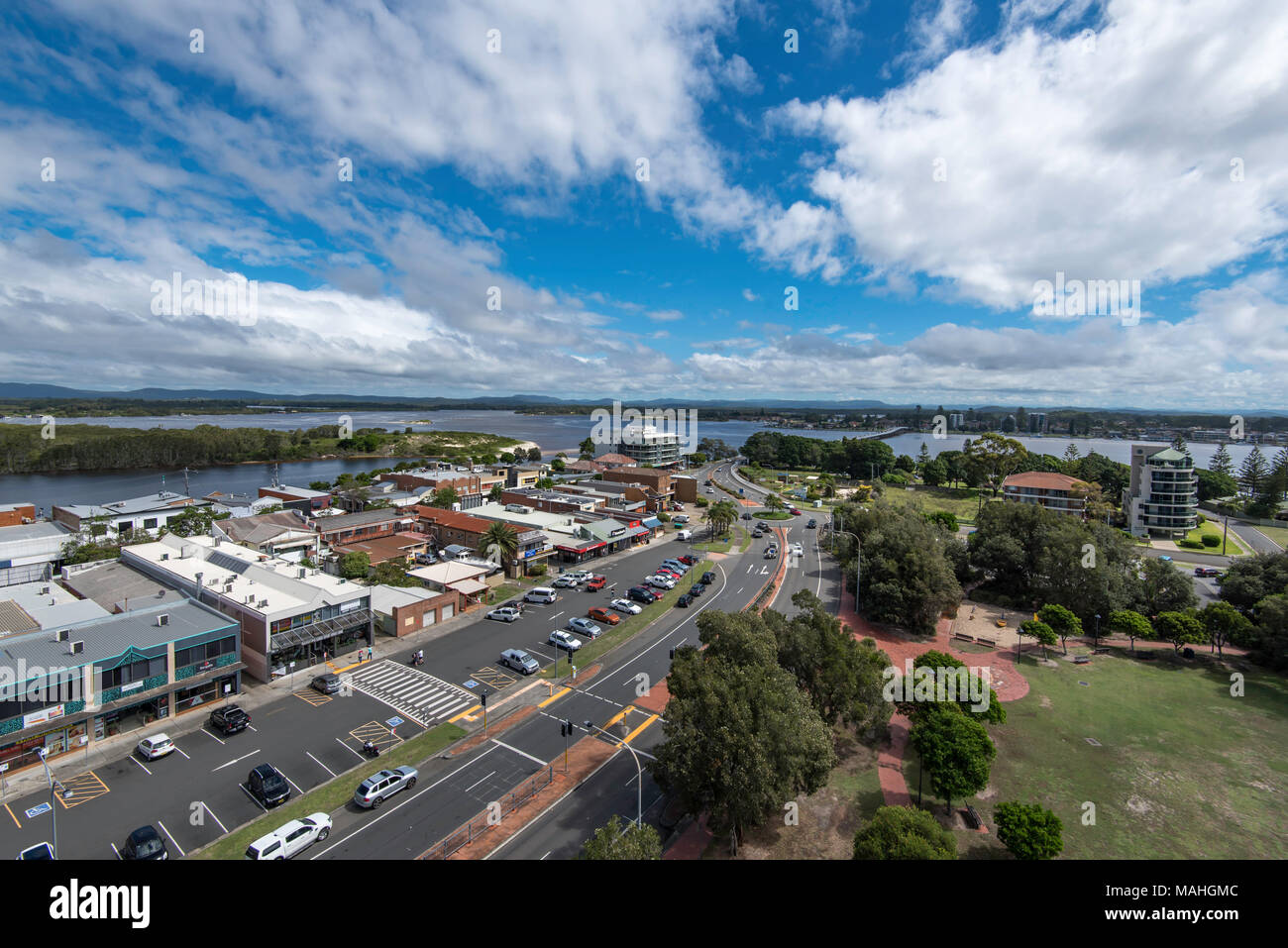 Die Haupteinkaufsstraße und Parkplatz in Forster NSW mit der Forster Tuncurry Brücke und Coolongolook Fluss im Hintergrund Stockfoto