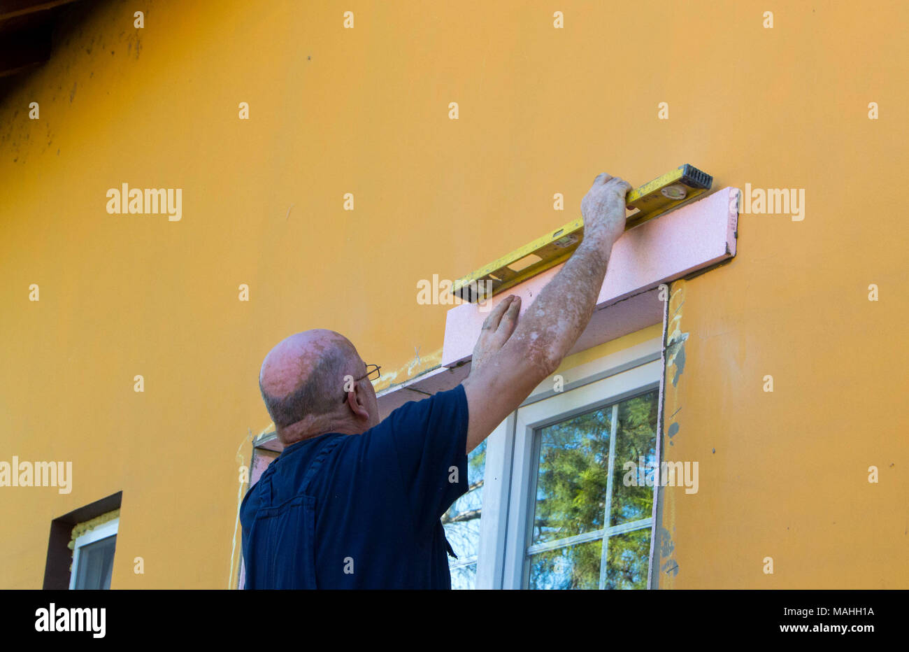 Der Arbeitnehmer Maßnahmen im Fenster. Installation eines neuen Fenster und Ausbauarbeiten um Sie herum Stockfoto