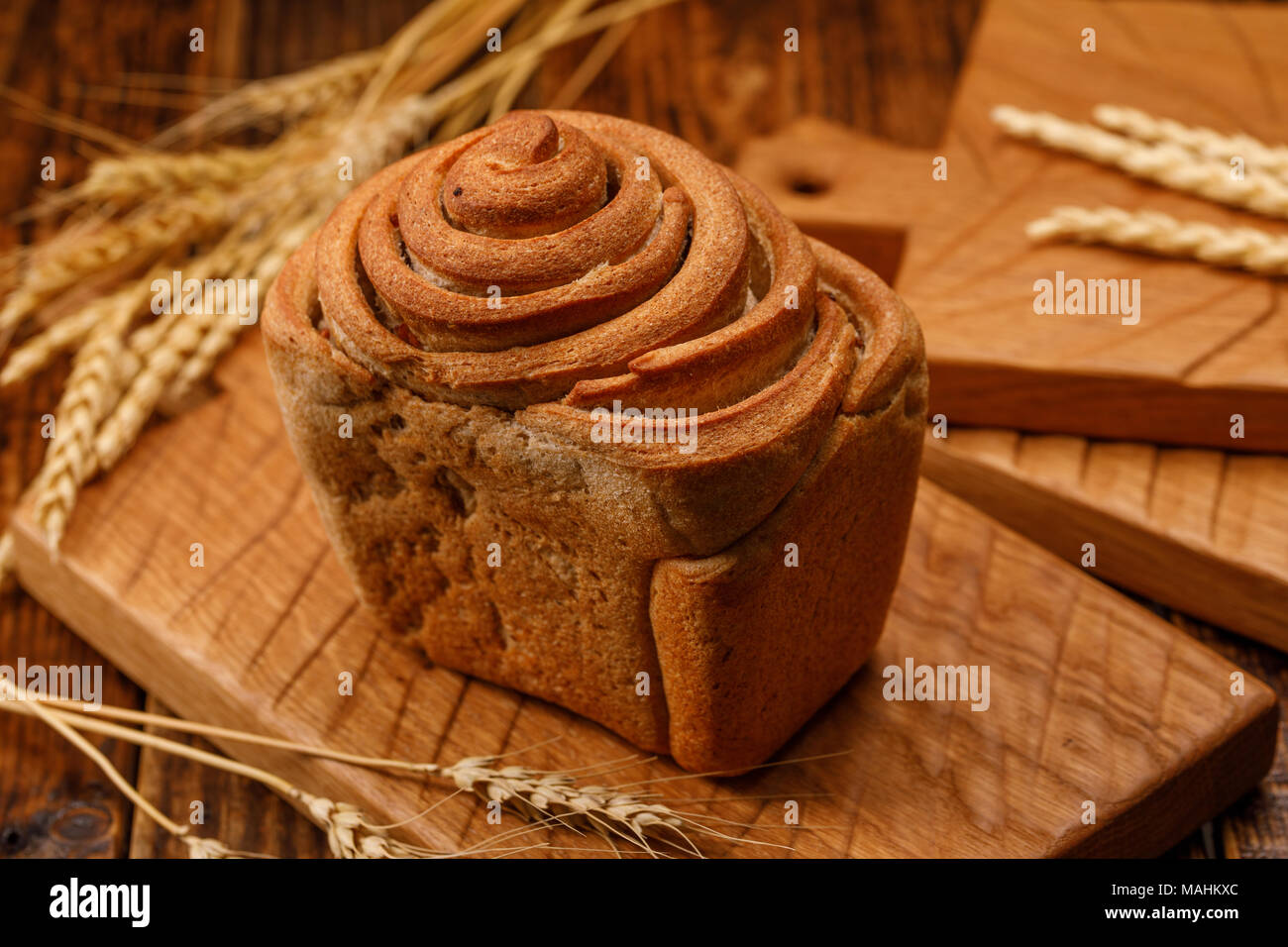 Schöne hausgemachte Brot auf einem Holzbrett. Eine schöne Kombination aus der Farbe eines Holz- Hintergrund und Brot. Close-up. Stockfoto