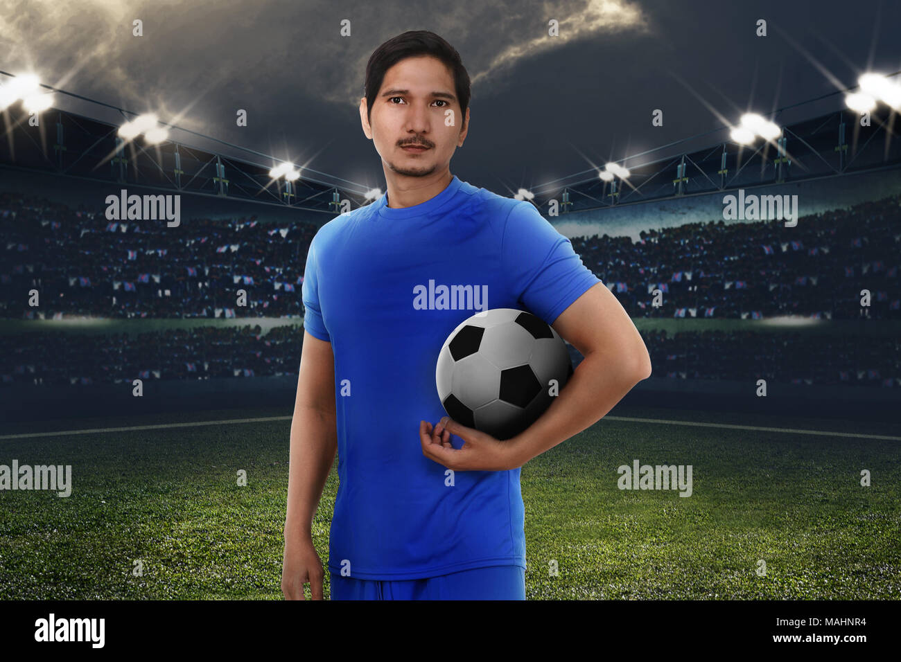 Stattliche Asian Football Player mit Fußball auf das Stadion Feld Stockfoto