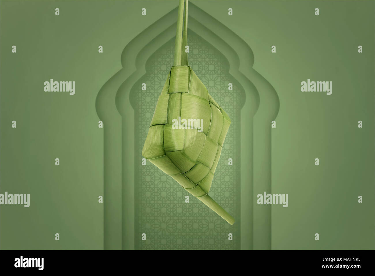 Von den jungen Kokosblättern hängen mit Moschee Hintergrund Ketupat Stockfoto