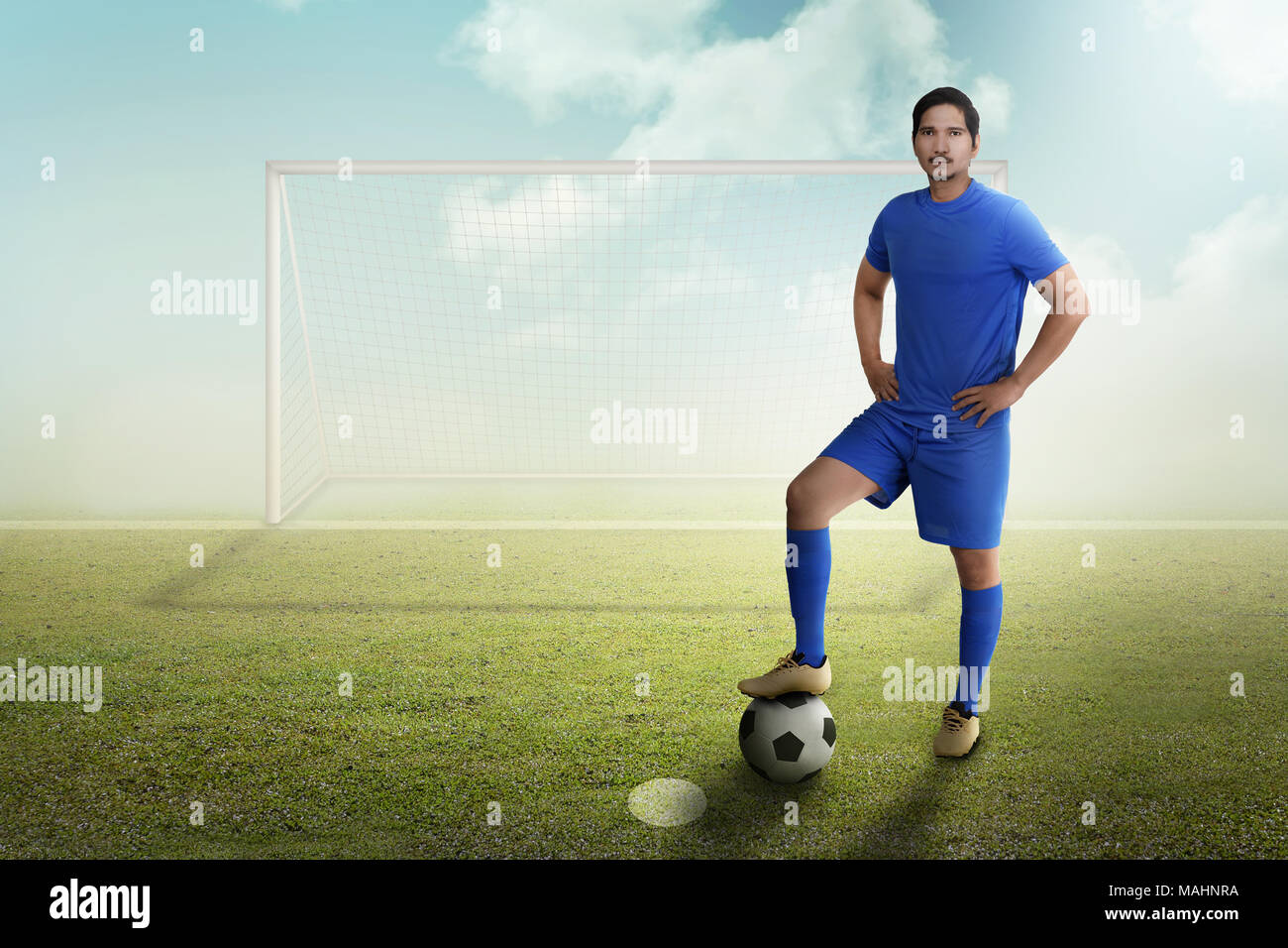 Jungen asiatischen Fußball-Spieler mit Ball auf dem Feld Stockfoto