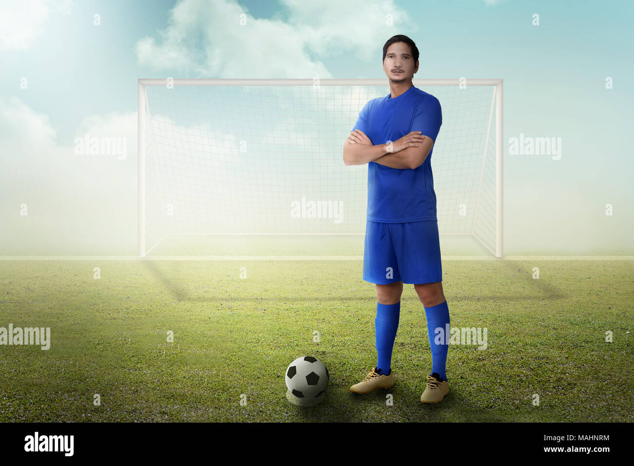 Stattliche Asian Football Player mit Arm stehend auf dem Feld gekreuzt Stockfoto