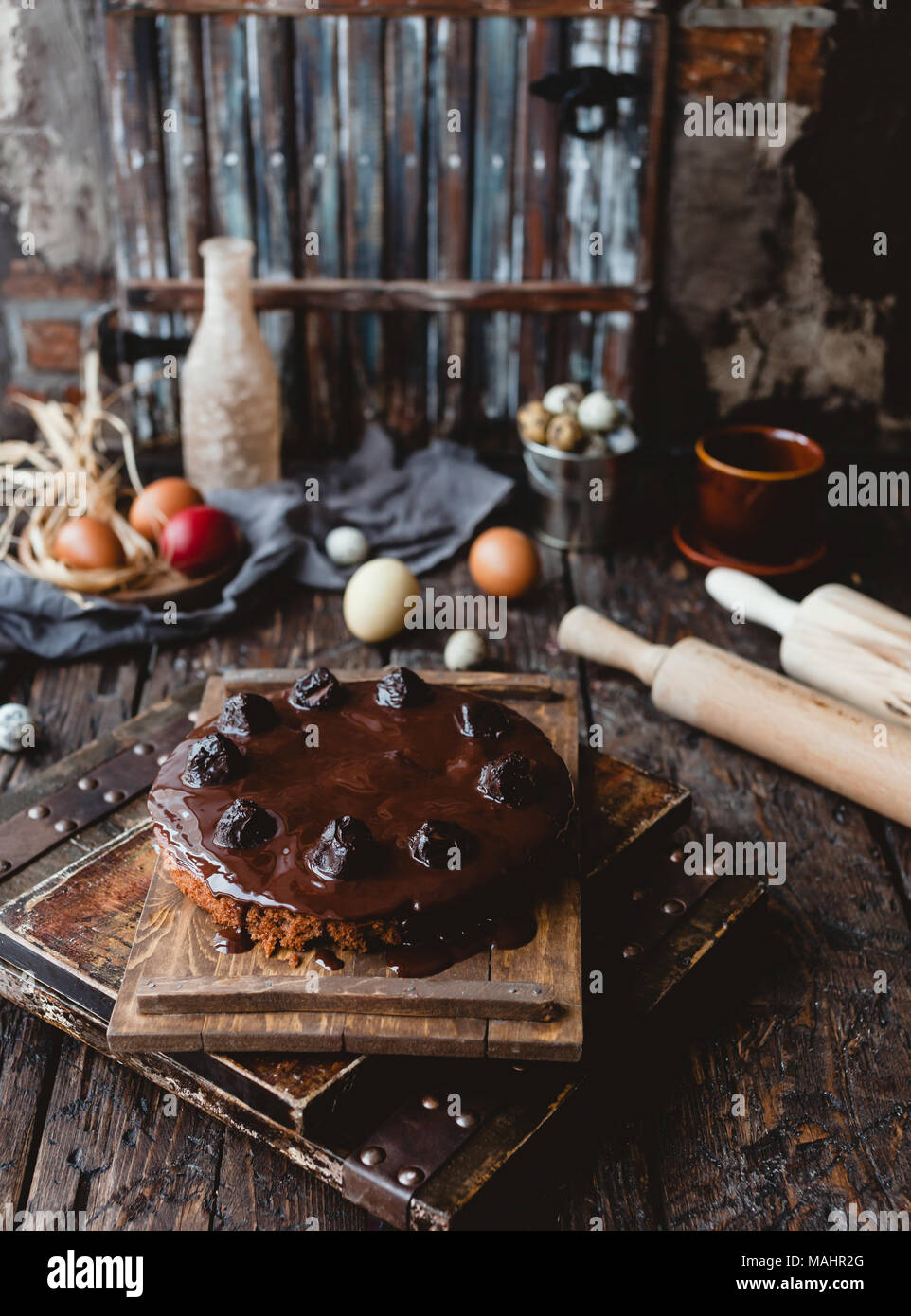 Ostern bunte Eier und Schokoladenkuchen auf rustikalen Holztisch Stockfoto