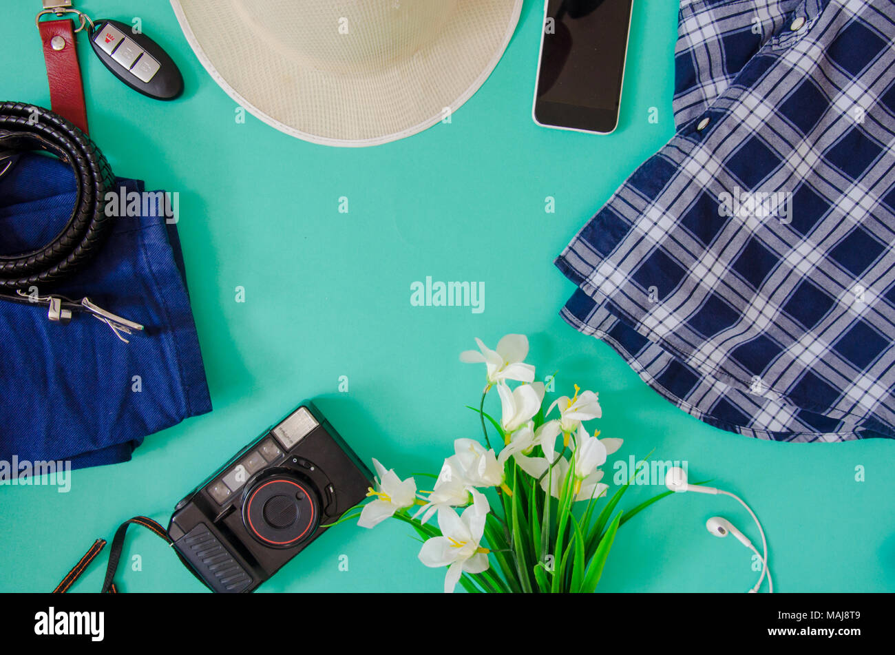 Traveler Zubehör. Hut, Kamera, Bekleidung, Blumen und Telefon auf dem grünen Hintergrund. Stockfoto