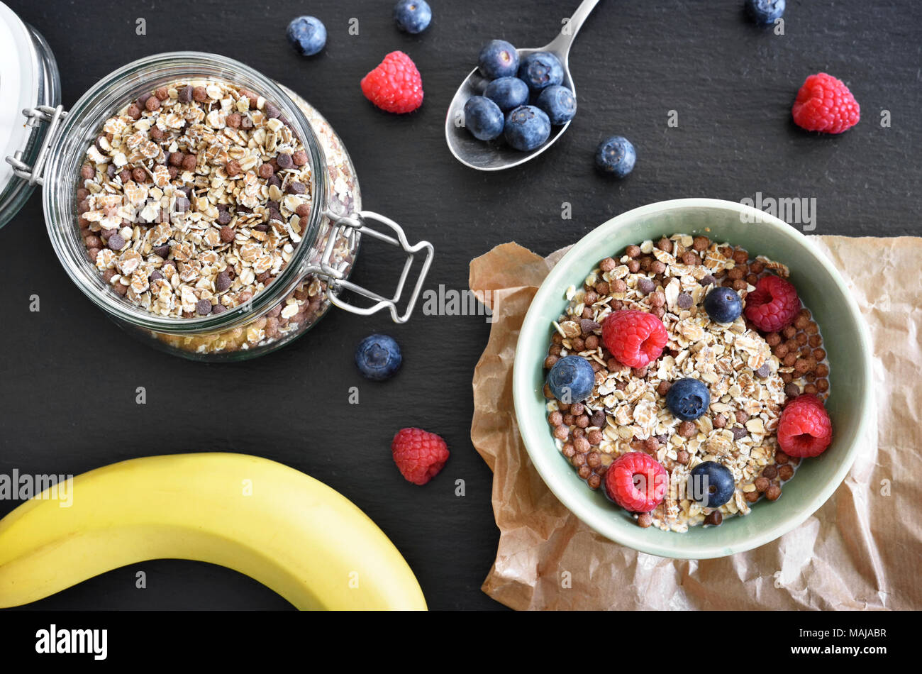 Getreide in einer Schüssel, Frühstück mit frischen Früchten und Müsli, das gesunde Essen. Frühstück Schüssel auf einem Holztisch, rustikalen Szene. Stockfoto