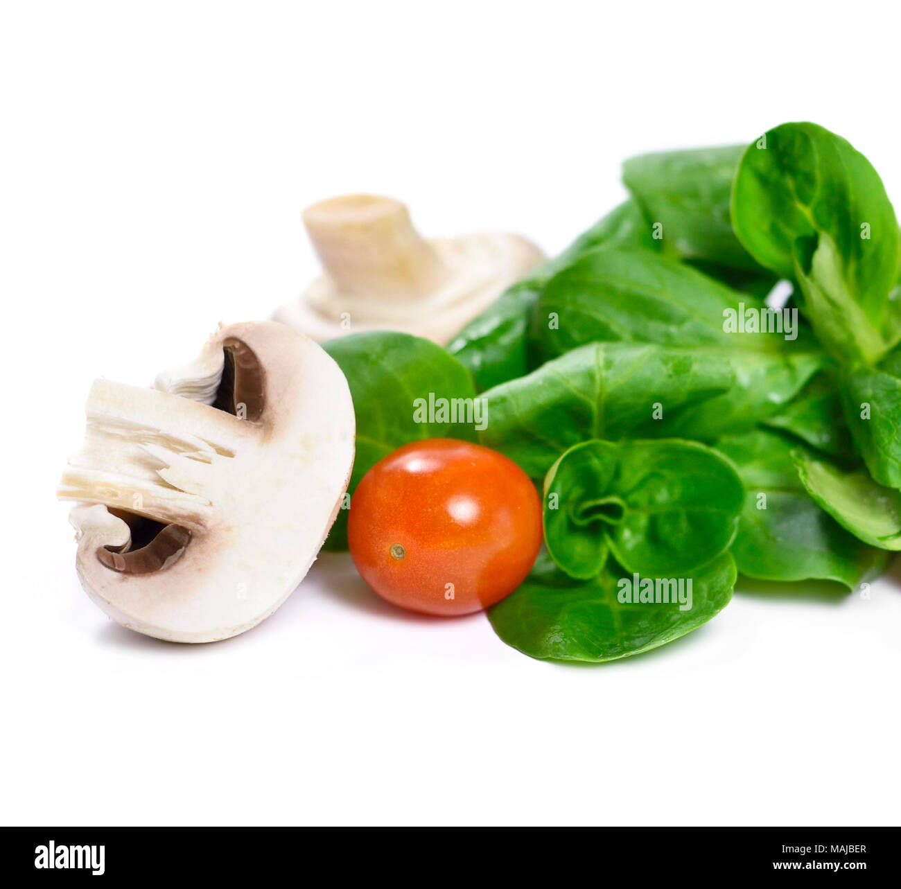 Frischen Feldsalat mit Cherry Tomaten und Champignons, auf weißem Hintergrund. Gesunde Ernährung Szene. Stockfoto