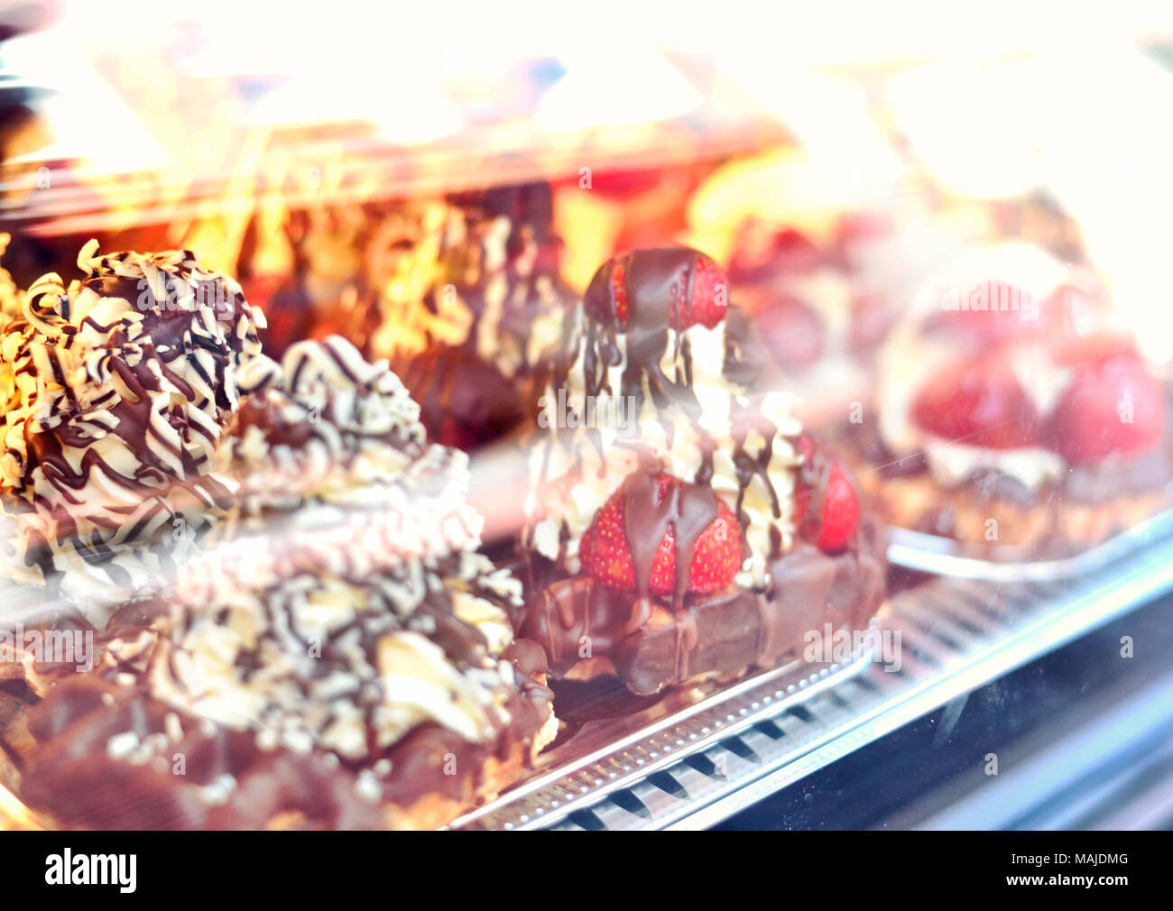 Köstliche belgische Waffeln mit Schokolade Sirup, Erdbeeren und Sahne. Schaufenster einer Bäckerei oder Candy Shop. Stockfoto