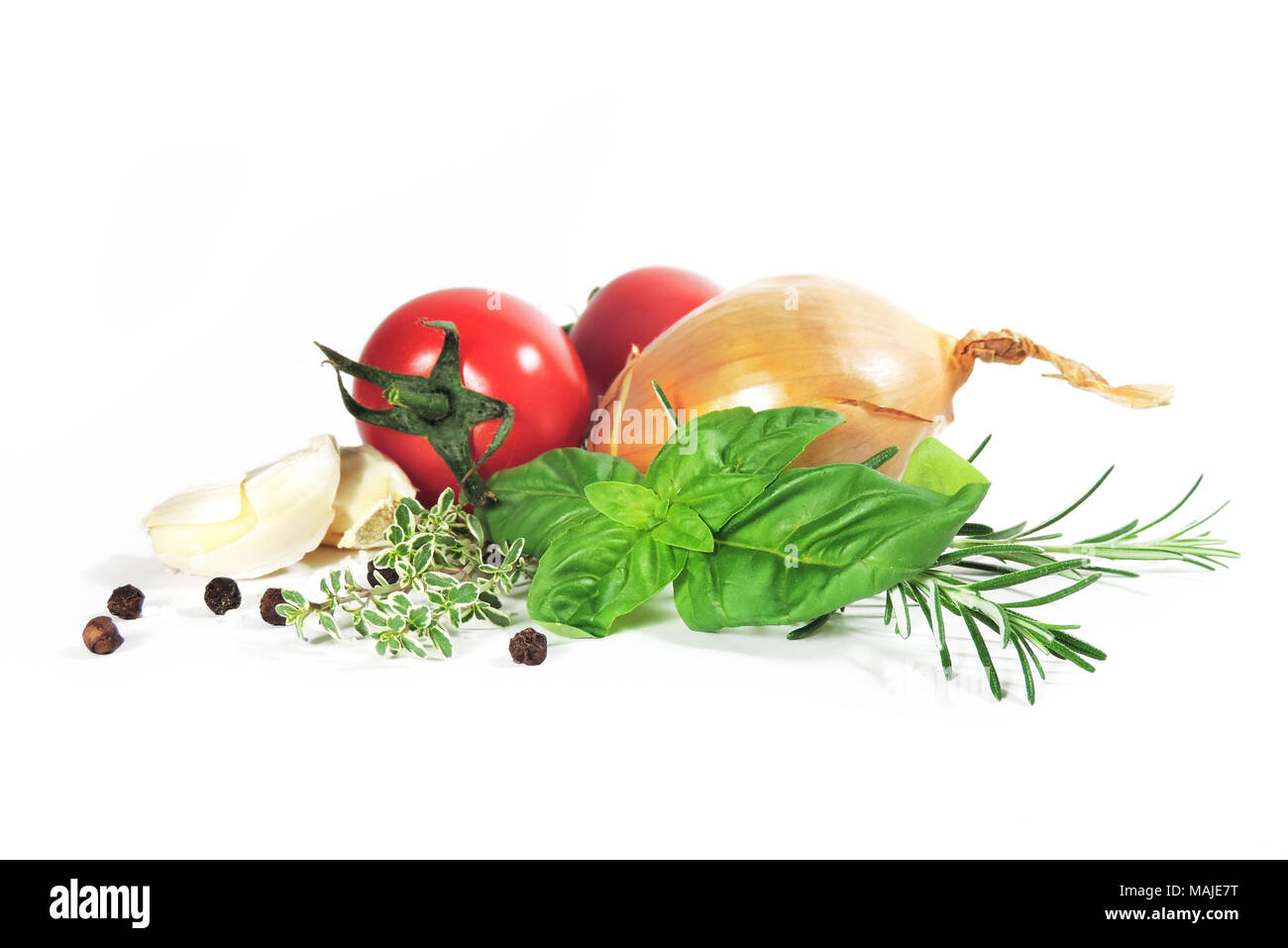 Frische Zutaten zum Kochen, auf weißem Hintergrund. Tomaten, Knoblauch, Zwiebel, Rosmarin, Thymian und schwarze Pfefferkörner, Anordnung von Gemüse. Stockfoto