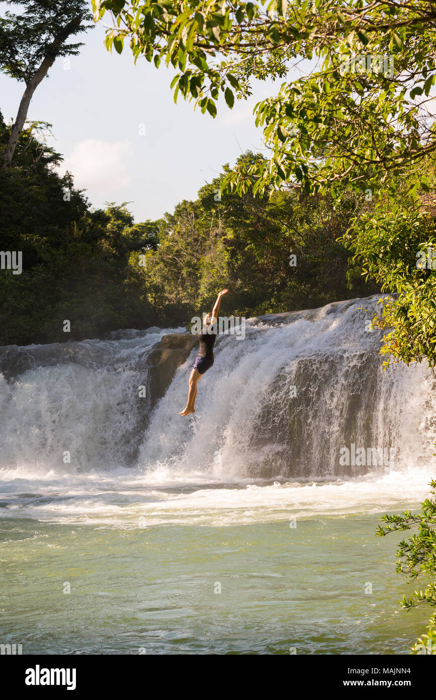 Weibliche adenture Reisenden springen Wasserfall in natürlichen Pool im Belize Stockfoto