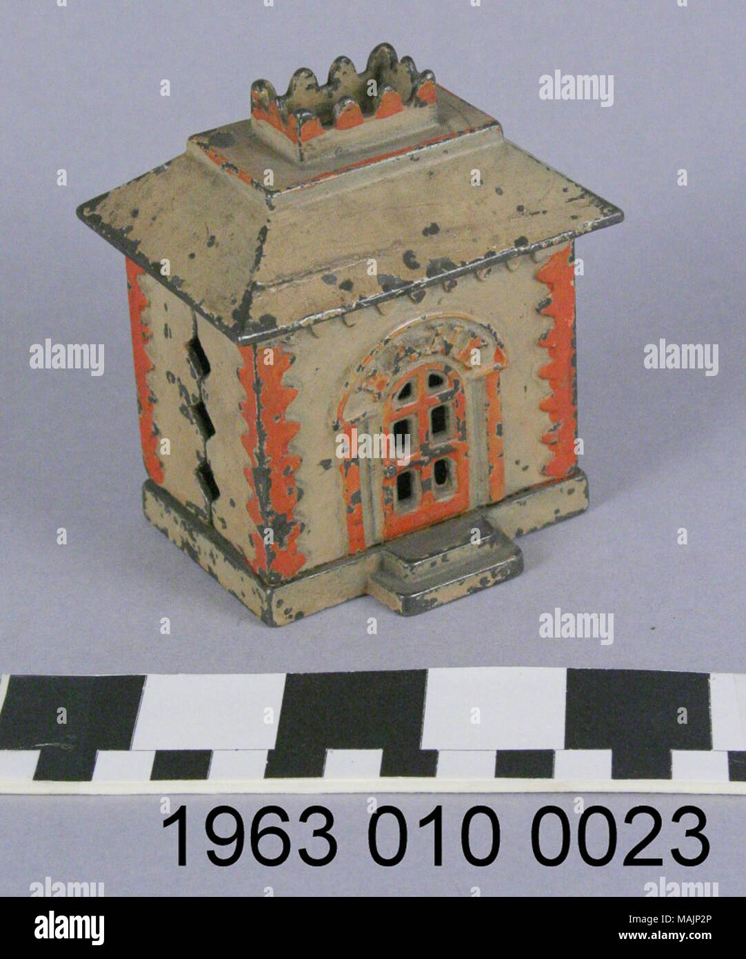 Eisen bank die Form einer Bank Gebäude, lackiert Creme und Orange mit dem Wort "Bank" über der Tür geworfen. Münze Steckplatz befindet sich auf der Rückseite. Titel: Bank Gebäude Coin Bank. Nach 1873. J und E Stevens Unternehmen Stockfoto