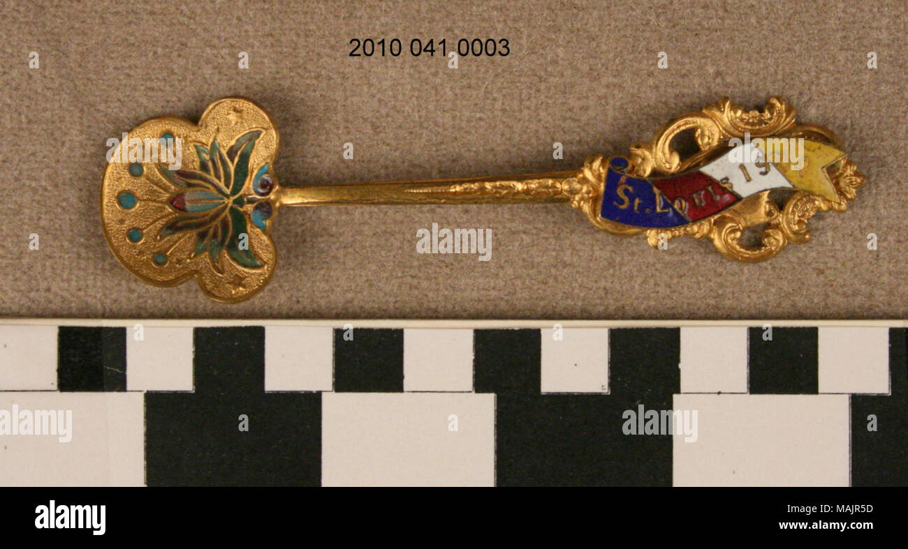 Goldfarbenem souvenir Löffel. Die Schüssel ist wie ein Kleeblatt, aber mit einer grösseren center Stück geprägt. Schüssel hat Blumenmotiv und Kreise. Dekorative Griff mit bunten Banner. Titel: 1904 World's Fair Souvenir Löffel. 1904. Stockfoto