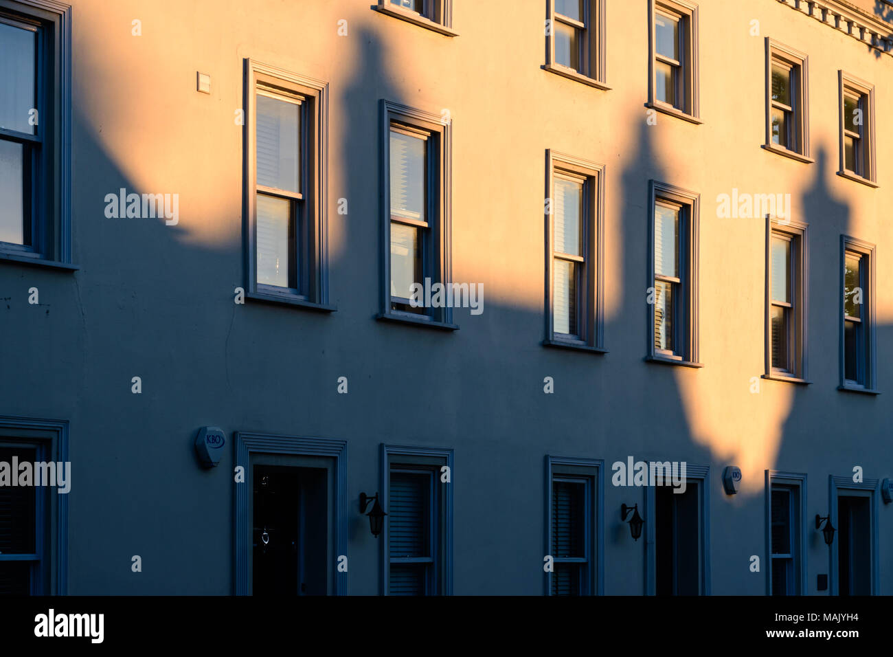 Die Schatten der drei Schornsteine fällt auf ein Gebäude Stockfoto
