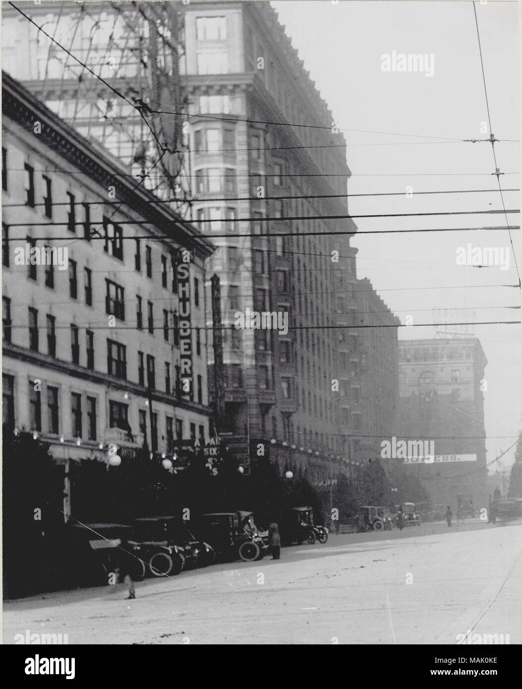 Vertikal, schwarz-weiß Foto Blick nach Norden auf der zwölften Straße (später Tucker Boulevard) an der Locust Street. Die linke Seite der Abbildung zeigt das Schubert Theater in der Union elektrische Gebäude, sowie mehreren Nebengebäuden. Tannen können hinter einer Reihe von geparkten Autos vor dem Theater gesehen werden. Hochspannungsleitungen kreuz und quer durch die Mitte des Bildes. Für ein Detail aus diesem Bild, siehe P 0054-00002. Ein typisiertes Hinweis auf der Rückseite des P 0054-00002 Drucken lautet: 'Nord in 12 Blbd.at Locust Street. Alte Shubert Theater war in der Union elektrische Gebäude, vor dem Zusatz von Fiv Stockfoto
