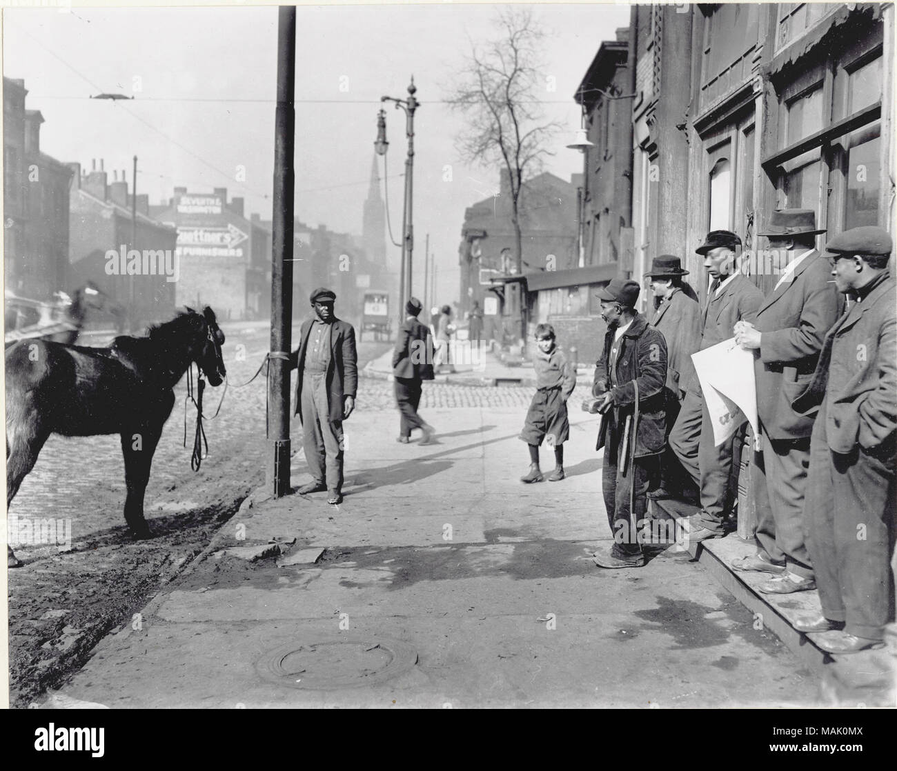 Titel: Gruppe meistens afroamerikanischer Männer stehen auf einem nicht identifizierten Straße Ecke. . Um 1910. Stockfoto