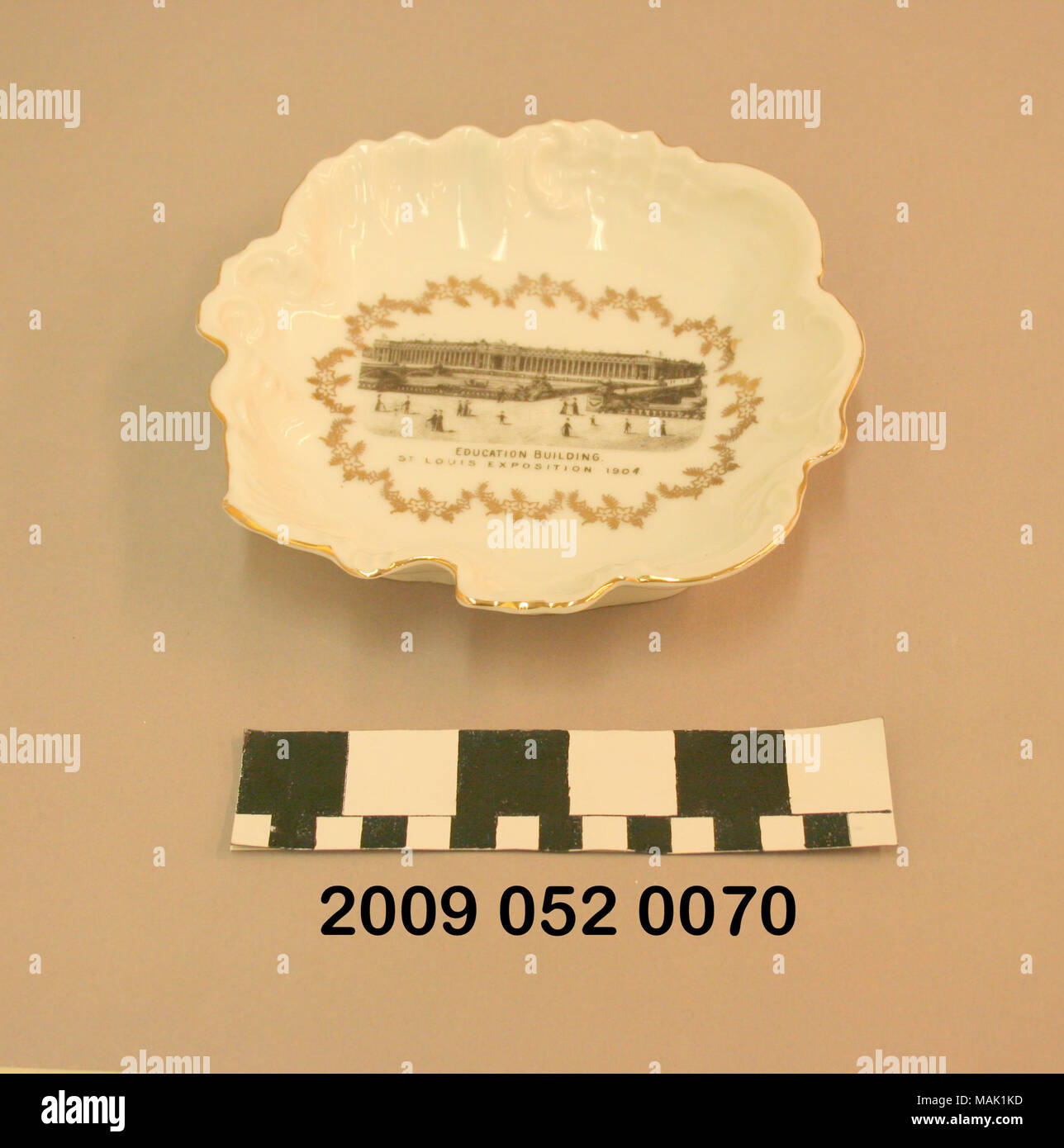 Weißer Keramik Candy Dish hat unregelmäßige Form mit Cut-outs um Grenze, vergoldete d+?cor, und Schwarz transfer Bild der Bildung Gebäude. Wahrscheinlich war dies ein Souvenir aus dem World's Fair 1904. Titel: weißer Keramik Candy Dish mit schwarzen Transfer Bild der Bildung Gebäude an der Weltausstellung in St. Louis 1904. 1904. Stockfoto