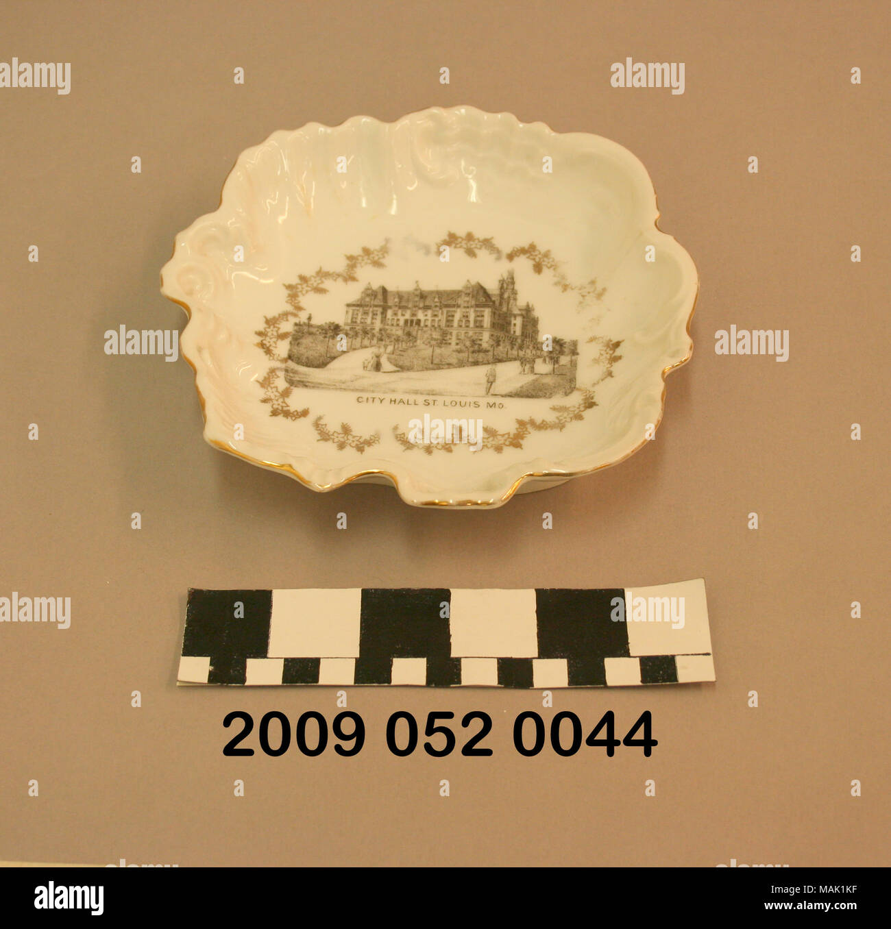 Weißer Keramik Candy Dish hat unregelmäßige Form mit Cut-outs um Grenze, vergoldete d+?cor, und Schwarz transfer Bild der Stadt Halle St. Louis MO. Wahrscheinlich war dies ein Souvenir aus dem World's Fair 1904. Titel: weißer Keramik Candy Dish mit schwarzen Transfer Bild der Stadt Halle St. Louis MO.. 1904. Stockfoto