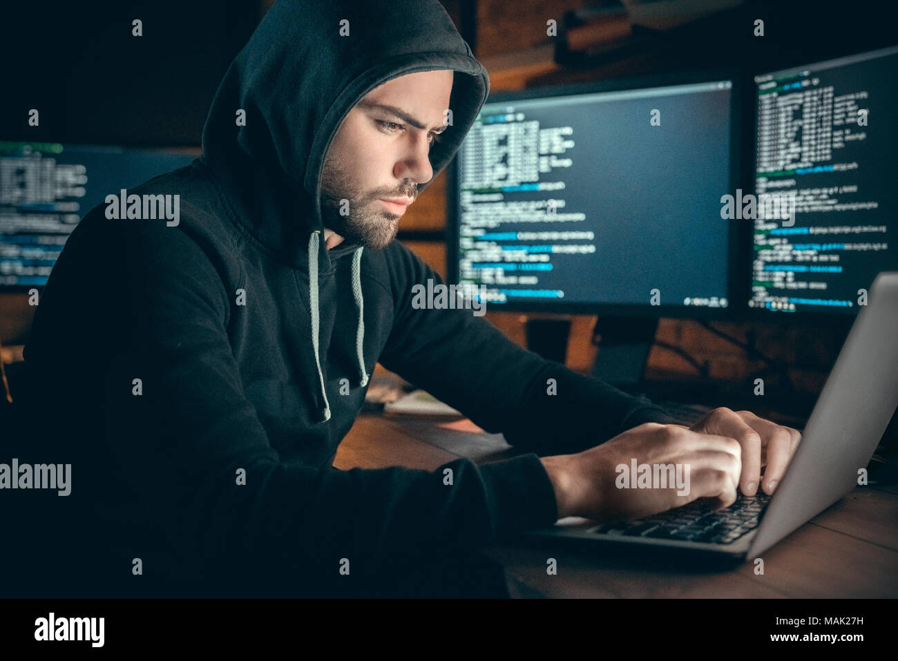 Junger Mann finanzielle Hacker im Büro am Tisch sitzend Arbeiten am Laptop zu hack System konzentriert Stockfoto