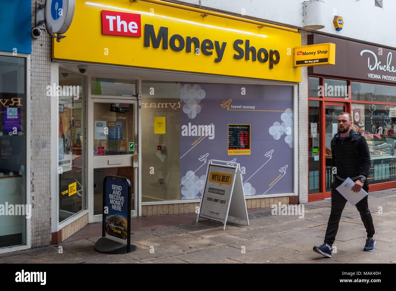 Geld Shop mit Mann zu Fuß in das Stadtzentrum von Coventry, West Midlands, UK. Stockfoto