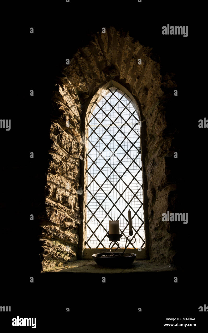 In der Nähe einer kleinen Kirche Fenster mit Kerzen auf dem Sims. Stockfoto In der Nähe einer kleinen Kirche Fenster mit Kerzen auf dem Sims. Stockfoto