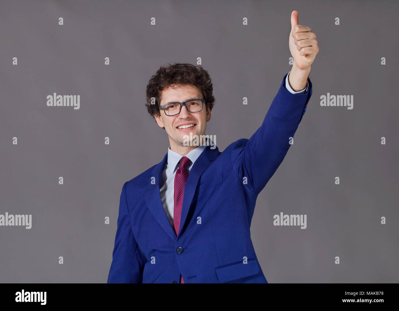 Ein Junge mit blauen Jacke und Krawatte zeigen großes Daumen hoch Stockfoto