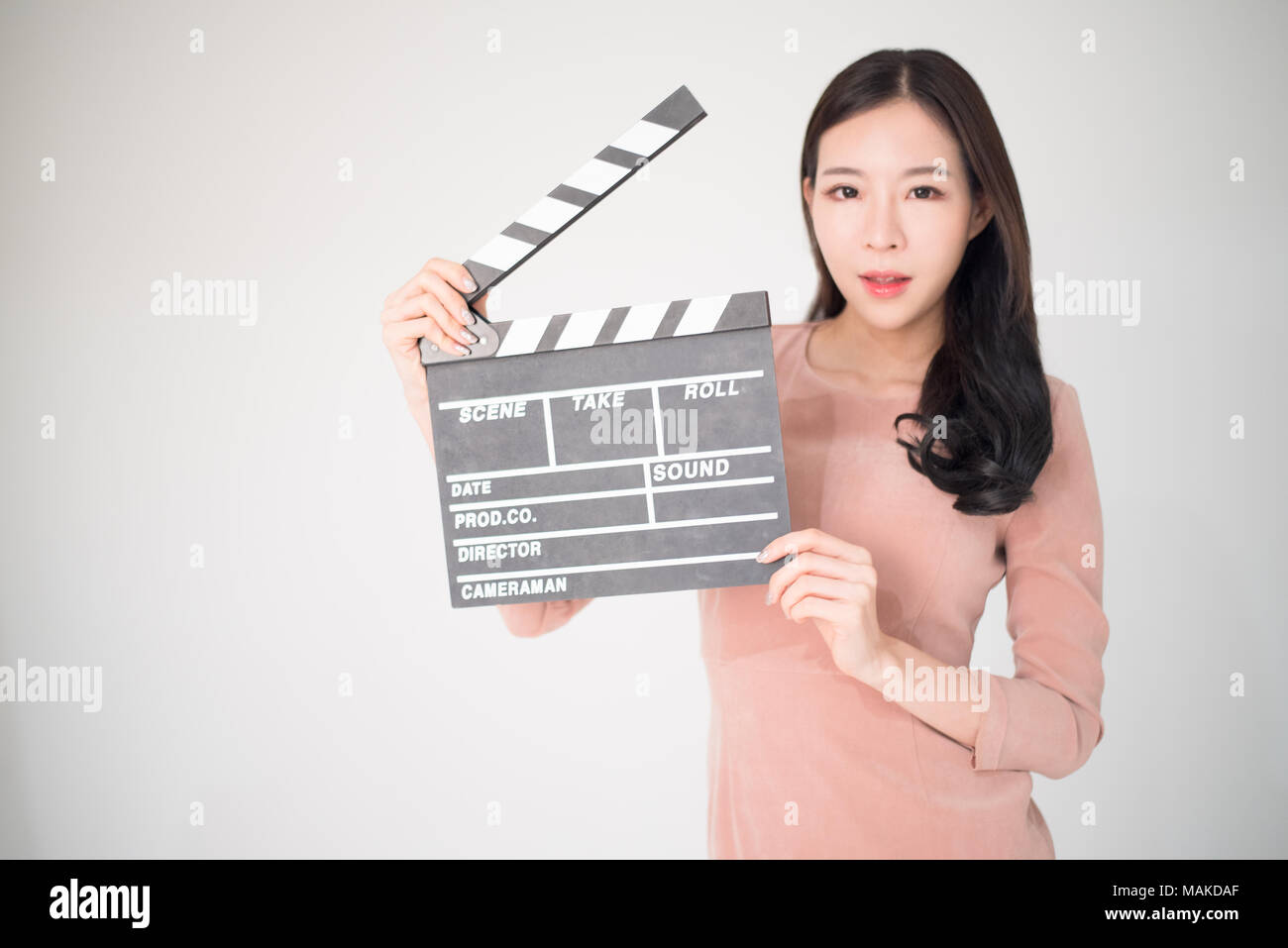 Sian Frau mit filmklappe Board auf weißem Hintergrund. Kinematografie, Kommunikation, Kultur, Casting, Audition, Film Produktion Konzept. Stockfoto