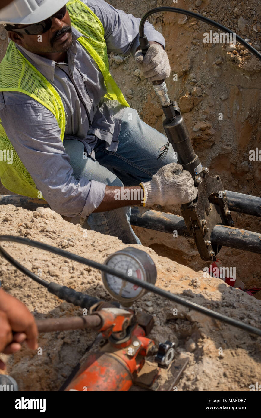 Eine Electrican schneiden heavy duty 11 kv3 Core elektrische Kabel auf der Baustelle Stockfoto