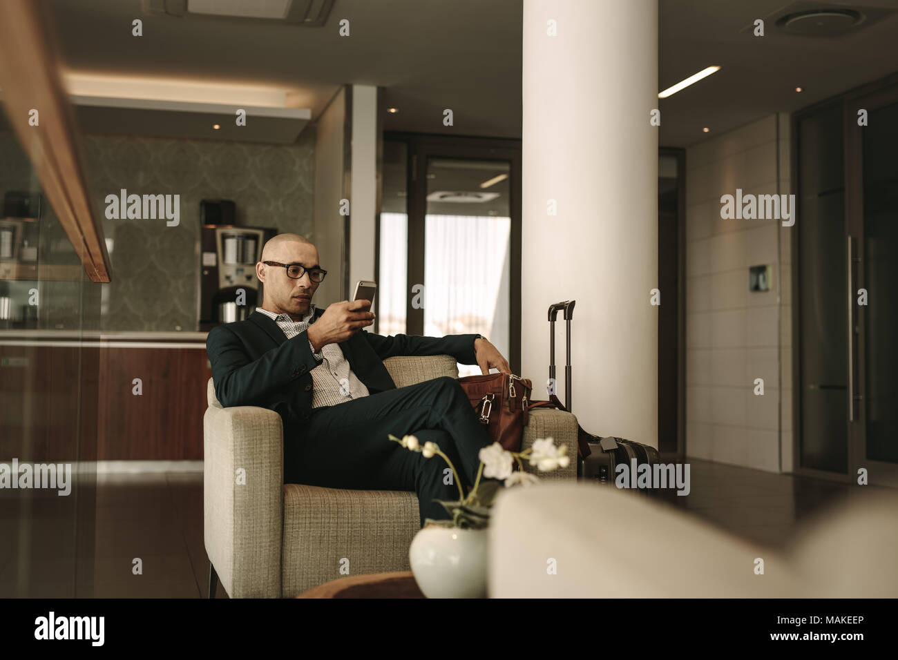 Geschäftsreisende in Airport Lounge warten und über Handy. Unternehmer warten auf Kampf an Airport Lounge. Stockfoto