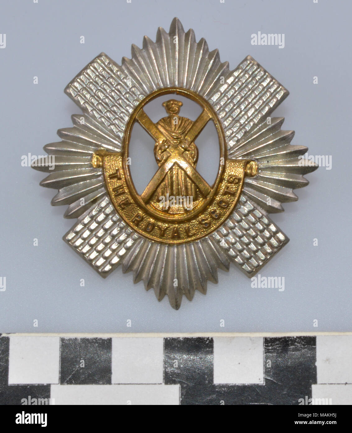 Weltkrieg Royal Scots Regiment Soldaten hat Abzeichen aus Messing und weißen Metall. St. Andrew ist in der Mitte ein Kreuz in Messing über einen Banner geprägte THE ROYAL SCOTS schneiden. Alle auf einem Kreuz und sun/star Burst in Silber. Titel: der Erste Weltkrieg Royal Scots Regiment Soldaten hat Abzeichen. Nach 1890. Stockfoto