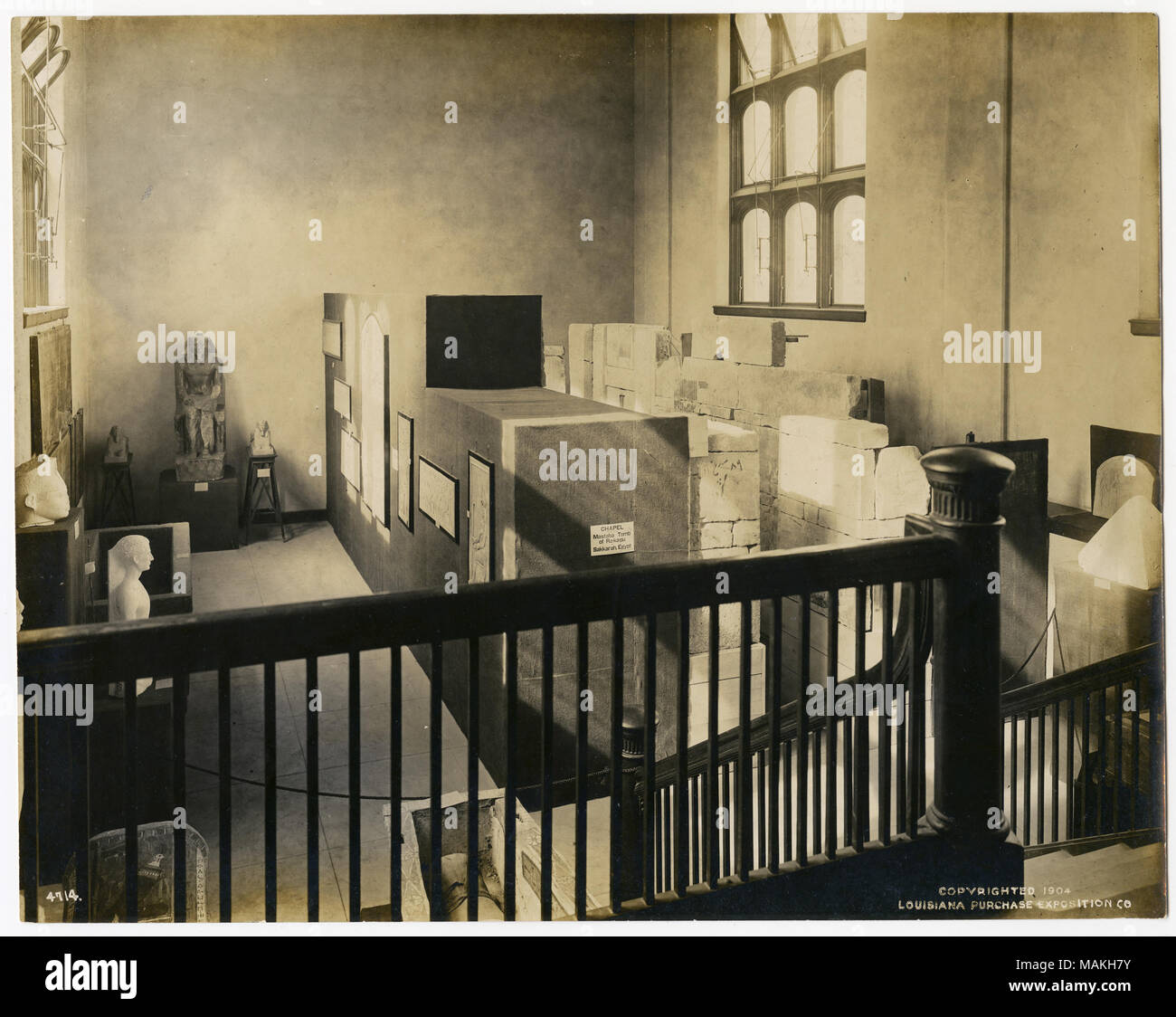 Horizontale, sepia Abbildung mit Zimmer anzeigen ägyptischer Artefakte. Auf der linken Seite befinden sich Skulpturen, und in der Mitte und auf der rechten Seite ist eine Anzeige der Wände mit Hieroglyphen. Die Ansicht ist von einem erhöhten Landung genommen, und ein Geländer und Treppe stehen im Vordergrund. Titel: Anzeige in der Abteilung für Anthropologie an der World's Fair 1904, ägyptischer Artefakte und Hieroglyphen. 1904. Offizielle fotografische Begleitung Stockfoto