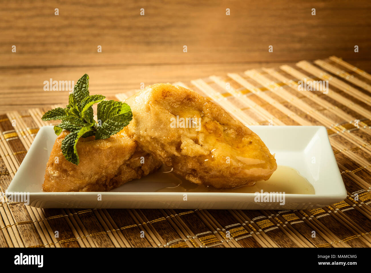 Noch immer leben in eine rechteckige Form mit zwei french toast mit Honig mit Minze auf Bambus matte eingerichtet Stockfoto