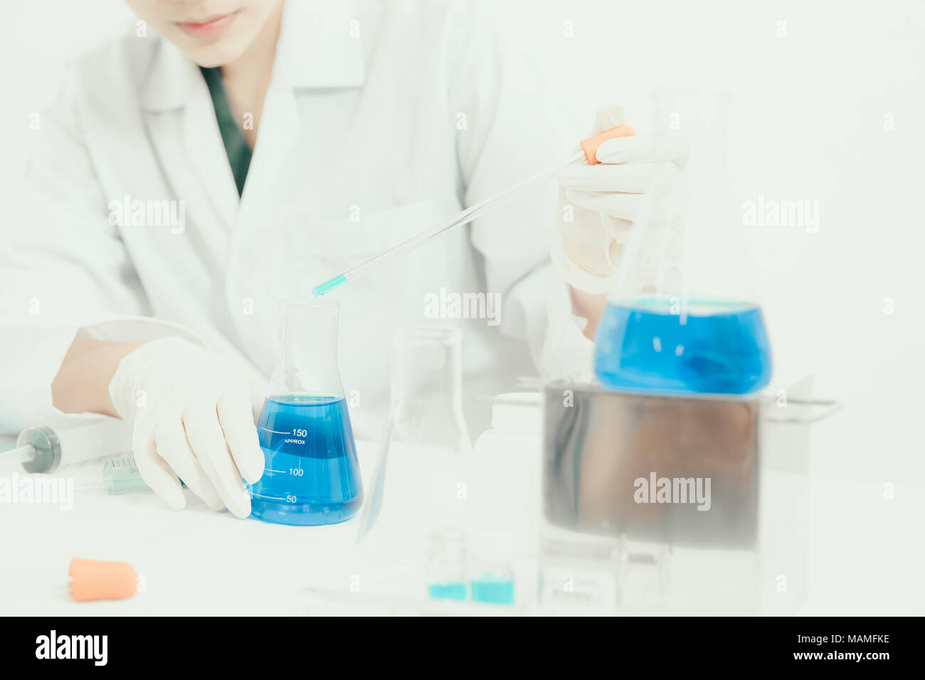 Junge Asiatische Wissenschaftler in der Toilette mit Reagenzgläsern und andere Ausrüstung neue Medikamente, Produkte und Methoden der Formulierung zu entdecken Stockfoto