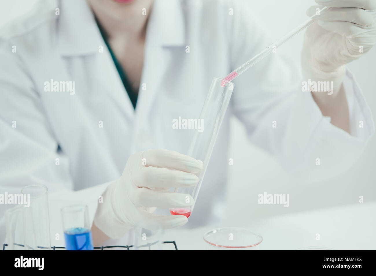 Junge Asiatische Wissenschaftler in der Toilette mit Reagenzgläsern und andere Ausrüstung neue Medikamente, Produkte und Methoden der Formulierung zu entdecken Stockfoto