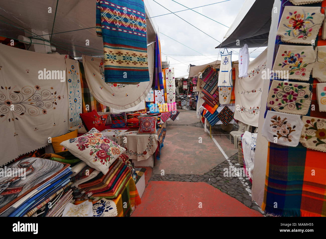 Otavalo, Ecuador-March 17, 2018: Anbieter steht mit bunten Waren im Samstag Handwerker Markt Stockfoto