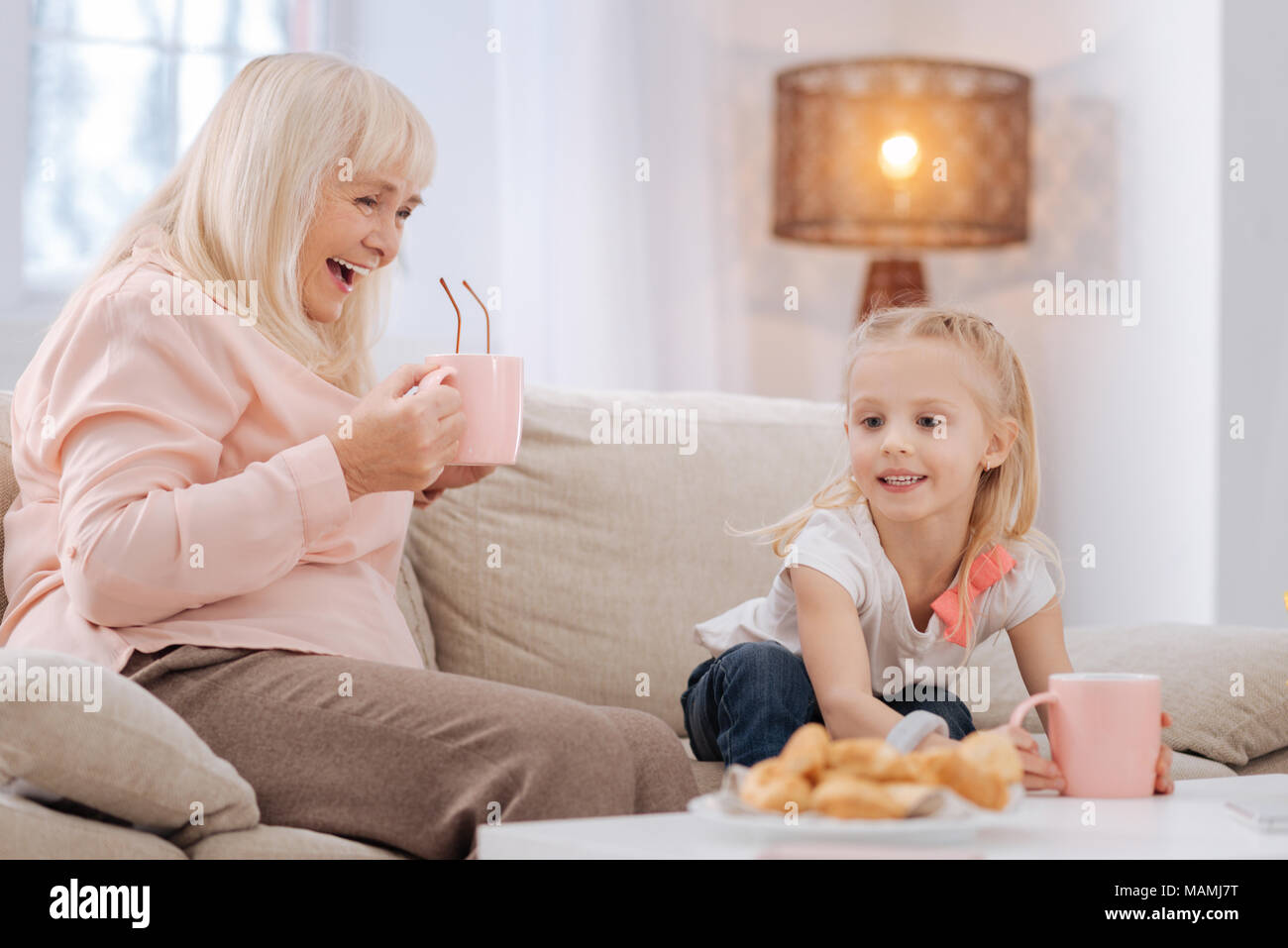 Schöne freudige Großmutter in Kaffee mit ihrer Enkelin Stockfoto