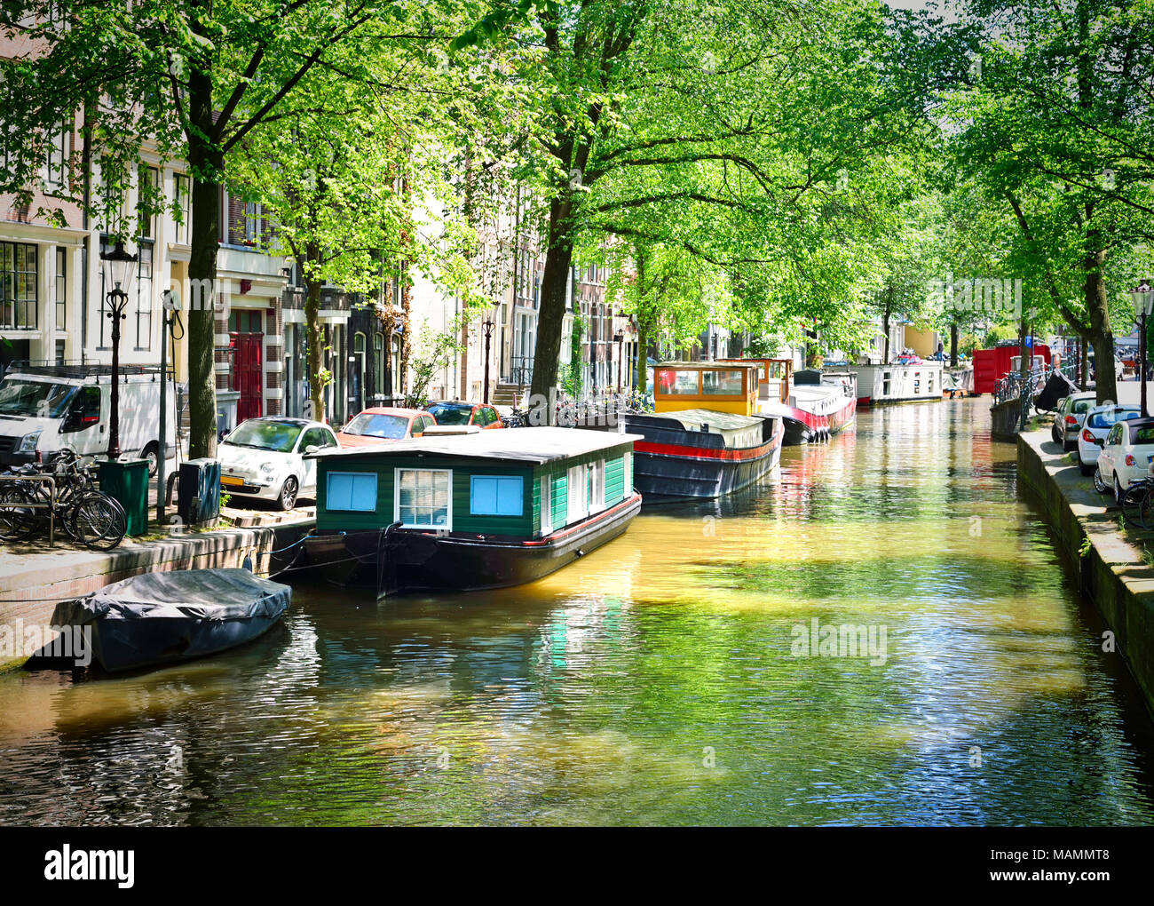 Kanal von Amsterdam mit dem niederländischen Häusern und Amstel. Im Frühling oder im Sommer zur Szene und das Stadtbild von Amsterdam. Historische Stadthäuser. Stockfoto