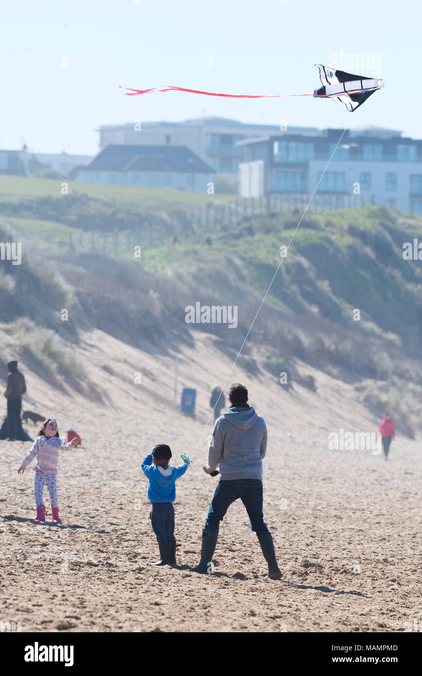 Ein Vater und seine Kinder flying a Kite auf den Fistral Beach in Newquay Cornwall. Stockfoto
